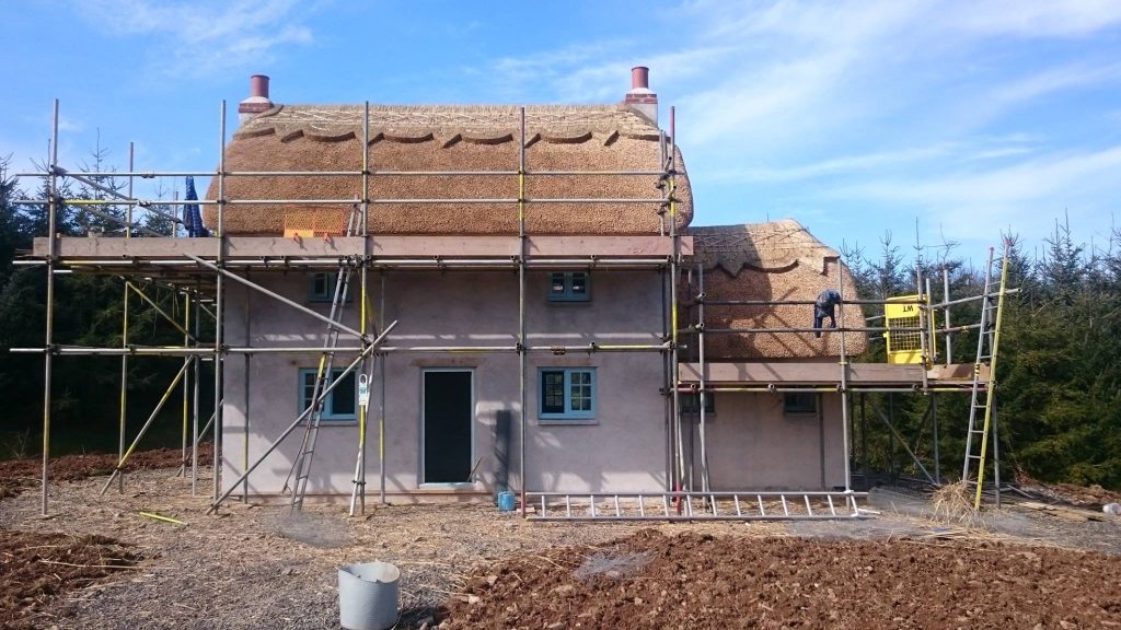 New build home with traditional thatched roof and ridge detail